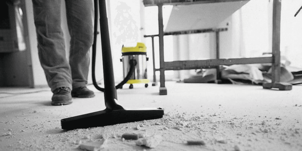 A newly constructed room being cleaned, with dust sheets on the floor.